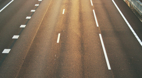 Close-up image of the asphalt and lane demarcations of a city street.