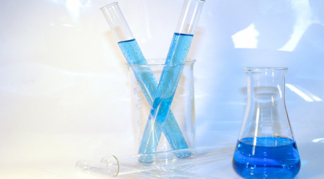 An Erlenmeyer flask half-filled with blue liquid and a beaker with two test tubes, also filled with blue liquid.