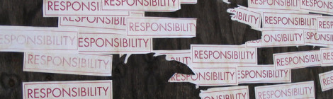 Multiple bumper stickers with the word "Responsibility" attached to a wall.