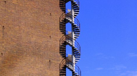 An ascending staircase, on the outside of a building, that resembles the DNA double helix. PHOTO © Artyom Korotkov/FreeImages.com